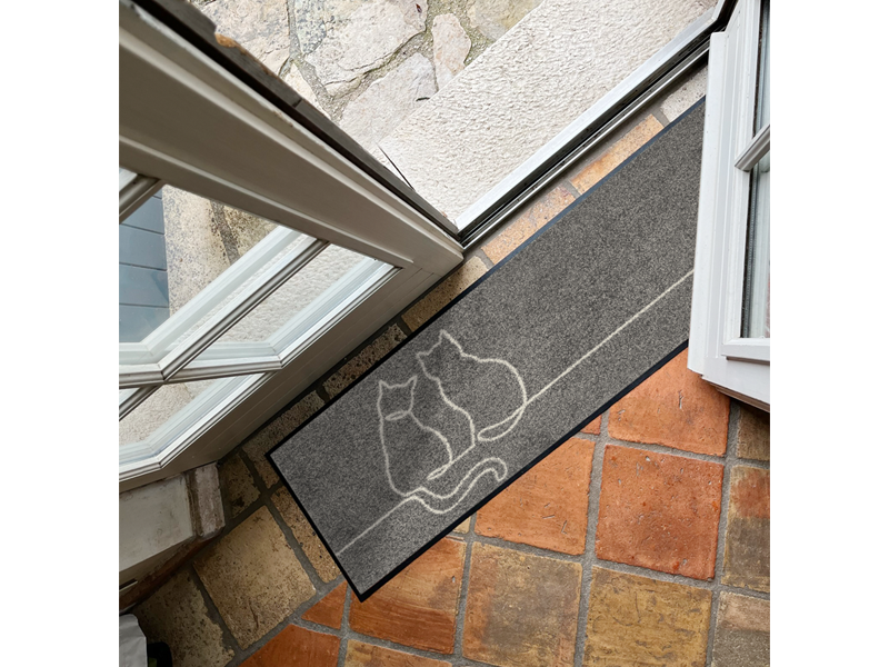 Fußmatte mit Katzenformen in grau vor der Tür