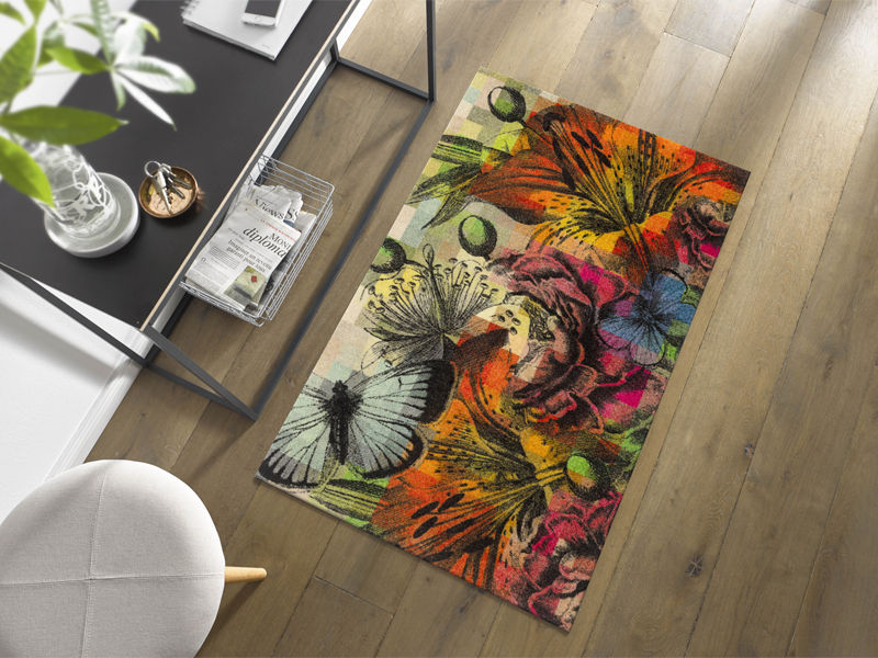 bunte Fußmatte mit Blumen und Schmetterlingen vor dem Garderobentisch