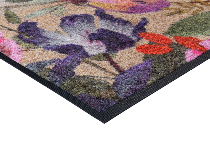 Eckansicht der Fußmatte in schwarz mit buntem, violettem Blumenmotiv