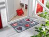 Fußmatte mit Herzmotiven in grau und rot vor der Eingangstür