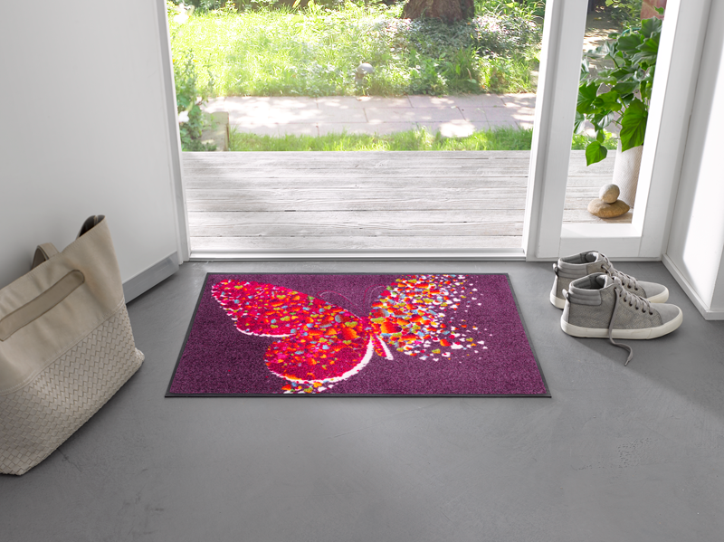 lila Fußmatte mit buntem Schmetterlingsmotiv im Eingangsbereich
