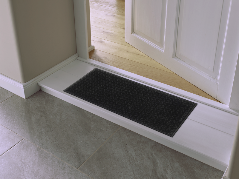 Fußmatte in schwarz dezent gemustert vor der Tür