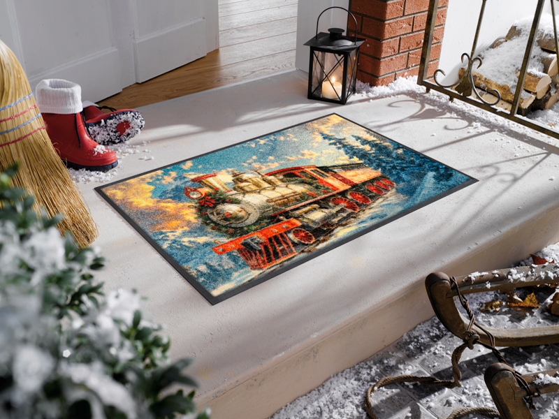 Fußmatte mit Zug in winterlicher Waldlandschaft vor der Tür