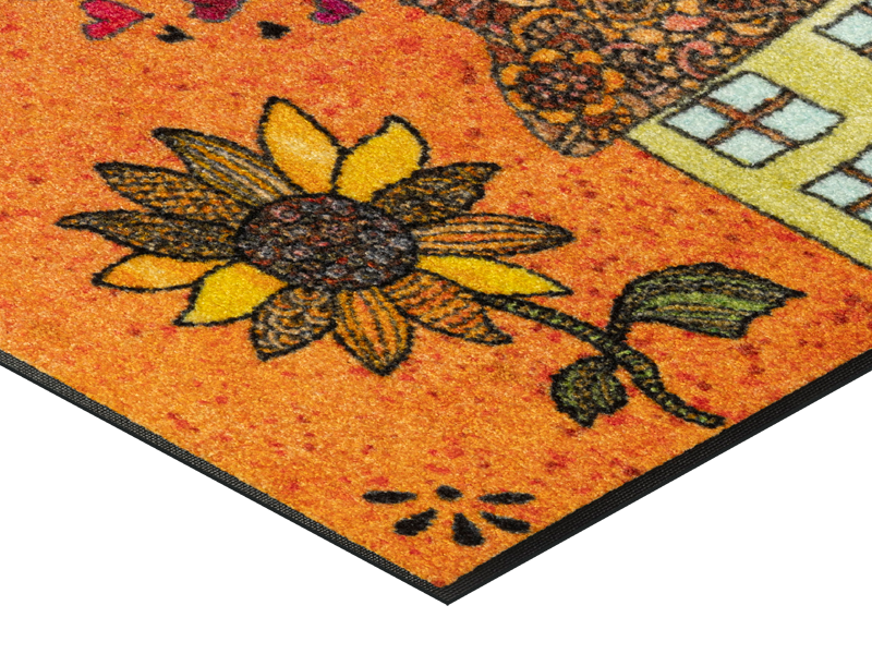 Eckansicht der Fußmatte mit gezeichnetem Haus und einer großen Sonnenblume