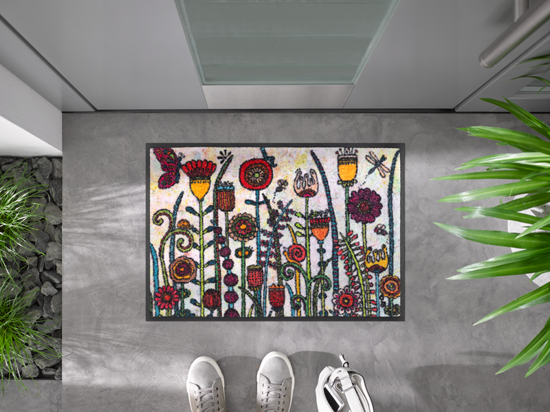 Fußmatte mit gemalenen Blumenmotiven vor der Tür