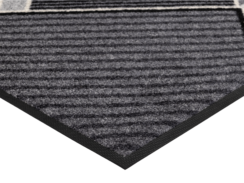 Eckansicht der Fußmatte mit grau-schwarzen Streifen in geometrischen Formen