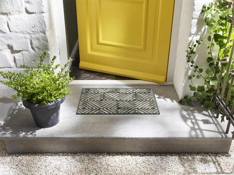 Fußmatte mit braun-grauem Rautendesign vor der Tür