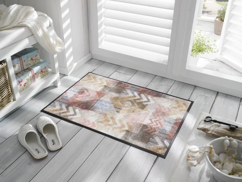 Fußmatte mit Pfeilen und Rauten Muster vor der Tür