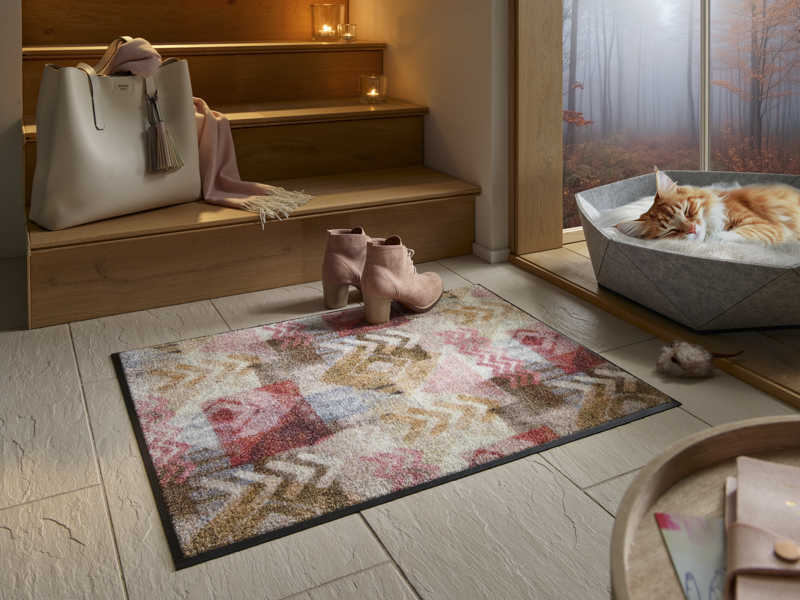 Fußmatte mit Pfeilen und Rauten Muster vor der Treppe