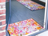 farbenfrohe Fußmatte mit bunten Farbkleksen im Eingangsbereich