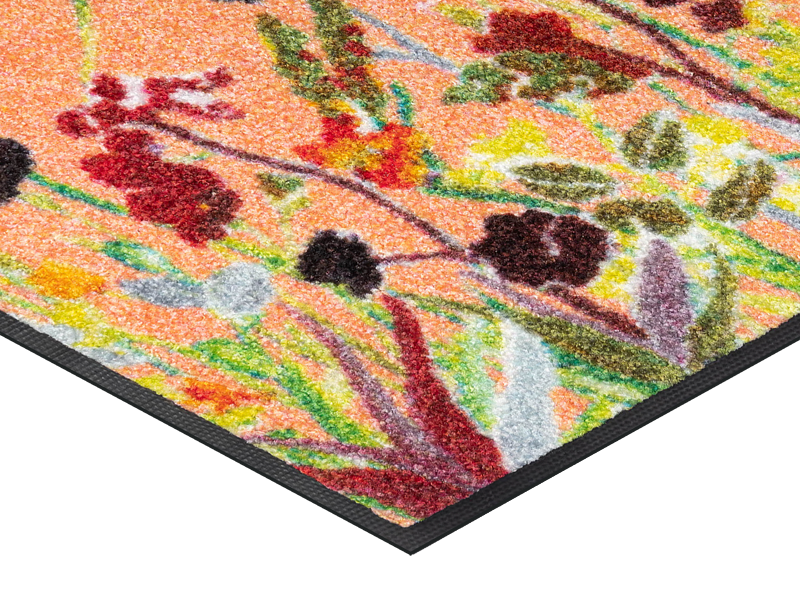 Eckansicht der Fußmatte in Rottönen mit farbenfrohen Blumen