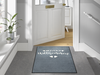 Fußmatte "Herzensgruss hoch" in grau mit Text " HERZLICH Willkommen" und Herzen in weiß vor der Tür