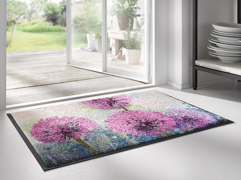 Fußmatte mit lilafarbenen Blumen vor der Tür